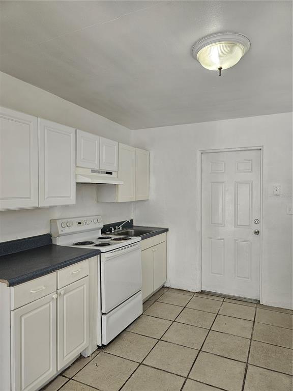 A kitchen with white cabinets, a white stove, a dark countertop, and tiled flooring — 1147 32ND STREET S, ST PETERSBURG, FL