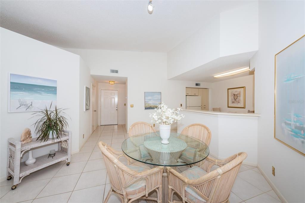 A dining area with a glass-topped table, wicker chairs, and tiled floors — 6151 BAHIA DEL MAR BOULEVARD UNIT 220, ST PETERSBURG, FL