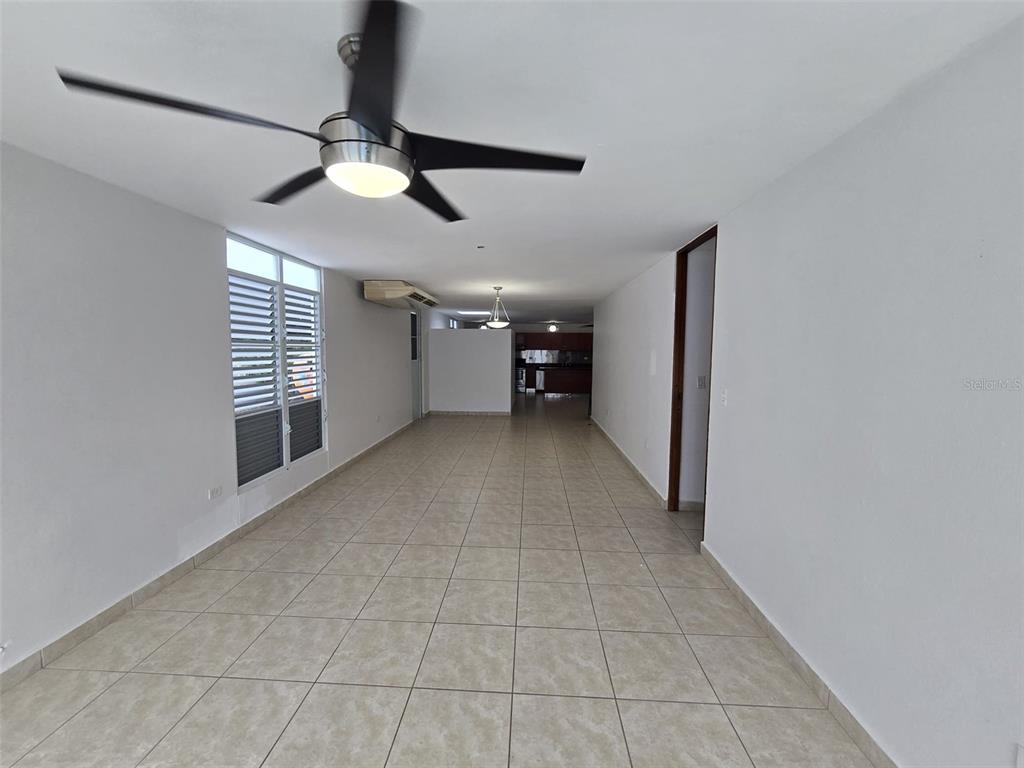A long, tiled living area features a ceiling fan and a view toward the kitchen — AE-5 CALLE BARCELONA, HUMACAO, PR