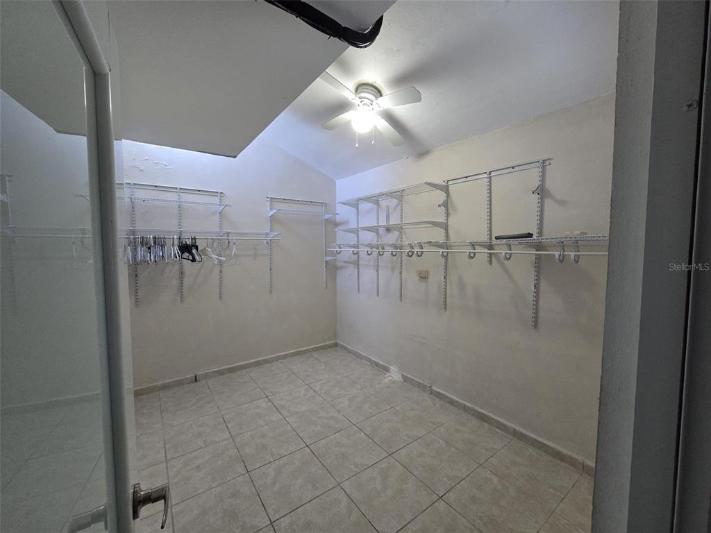 A walk-in closet features white wire shelving, tiled flooring, and a ceiling fan — AE-5 CALLE BARCELONA, HUMACAO, PR