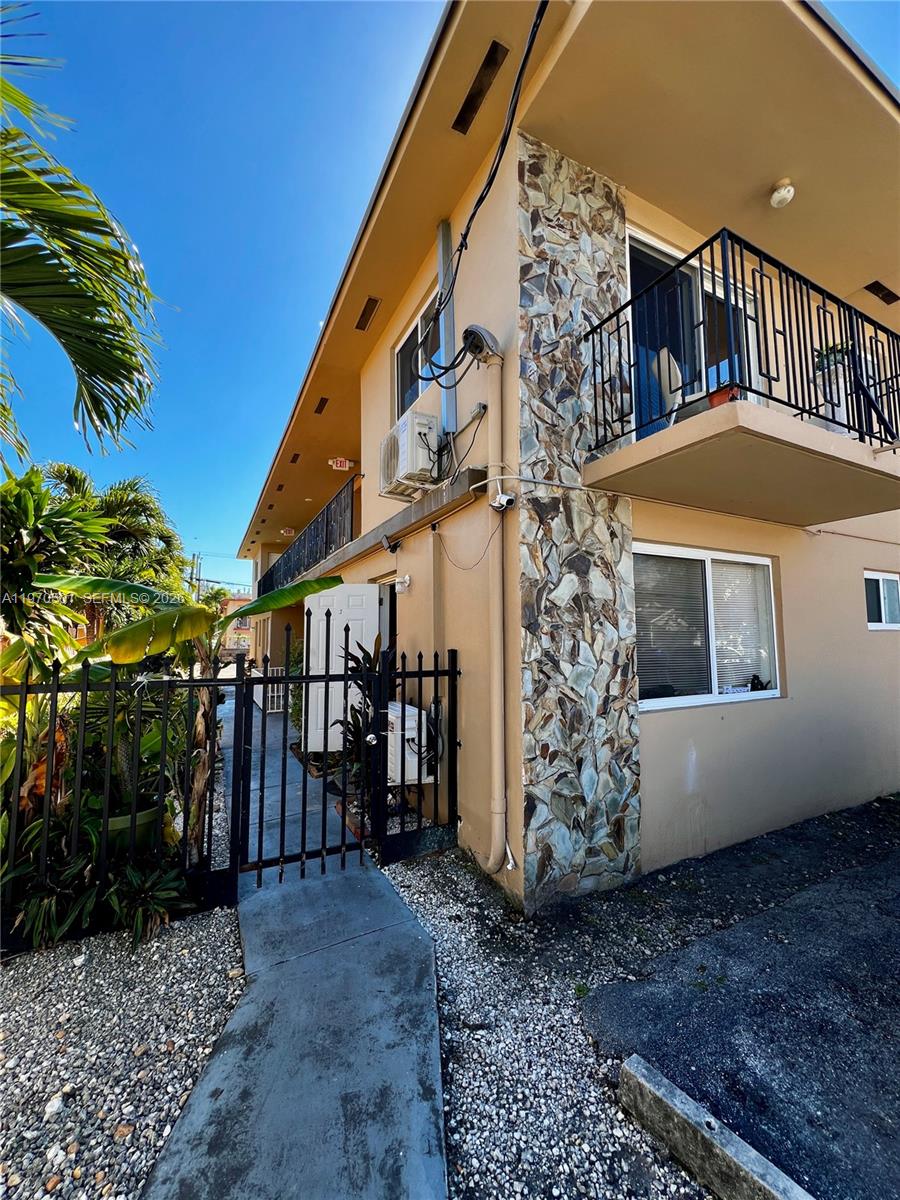 An exterior view of a two-story apartment building with a stone-accented wall and balcony — 1836 SW 6th St, Miami FL 33135, MIAMI, FL