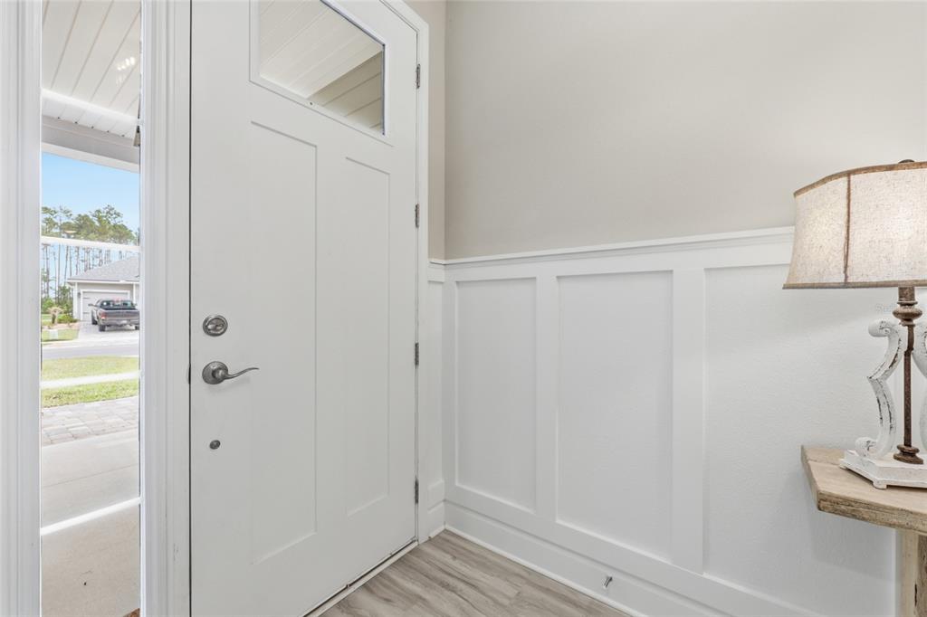 An entryway features a white door with a window, board and batten walls, and flooring — 192 GOLDENROD DRIVE, ST AUGUSTINE, FL