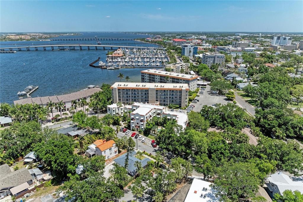 An aerial view shows a waterfront apartment complex, a marina, and a bridge — 210 N 17TH STREET W UNIT 14, BRADENTON, FL