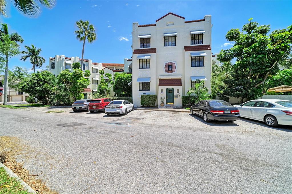 A three-story apartment building with a parking lot in front under a blue sky — 210 N 17TH STREET W UNIT 14, BRADENTON, FL
