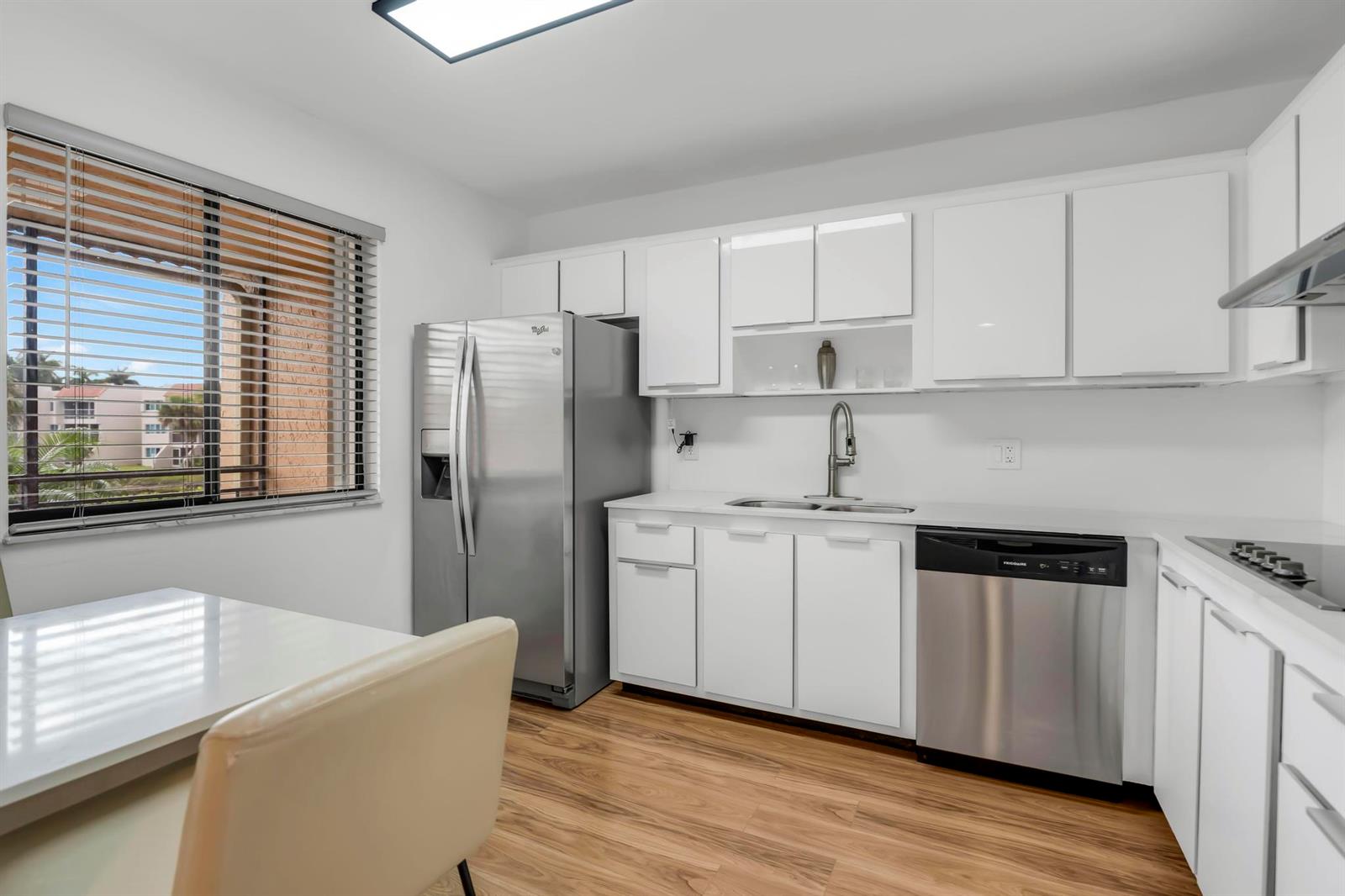 A kitchen with white cabinets, stainless steel appliances, and a window overlooking a residential complex — 170 Lakeview Drive # 203, Weston FL 33326, WESTON, FL