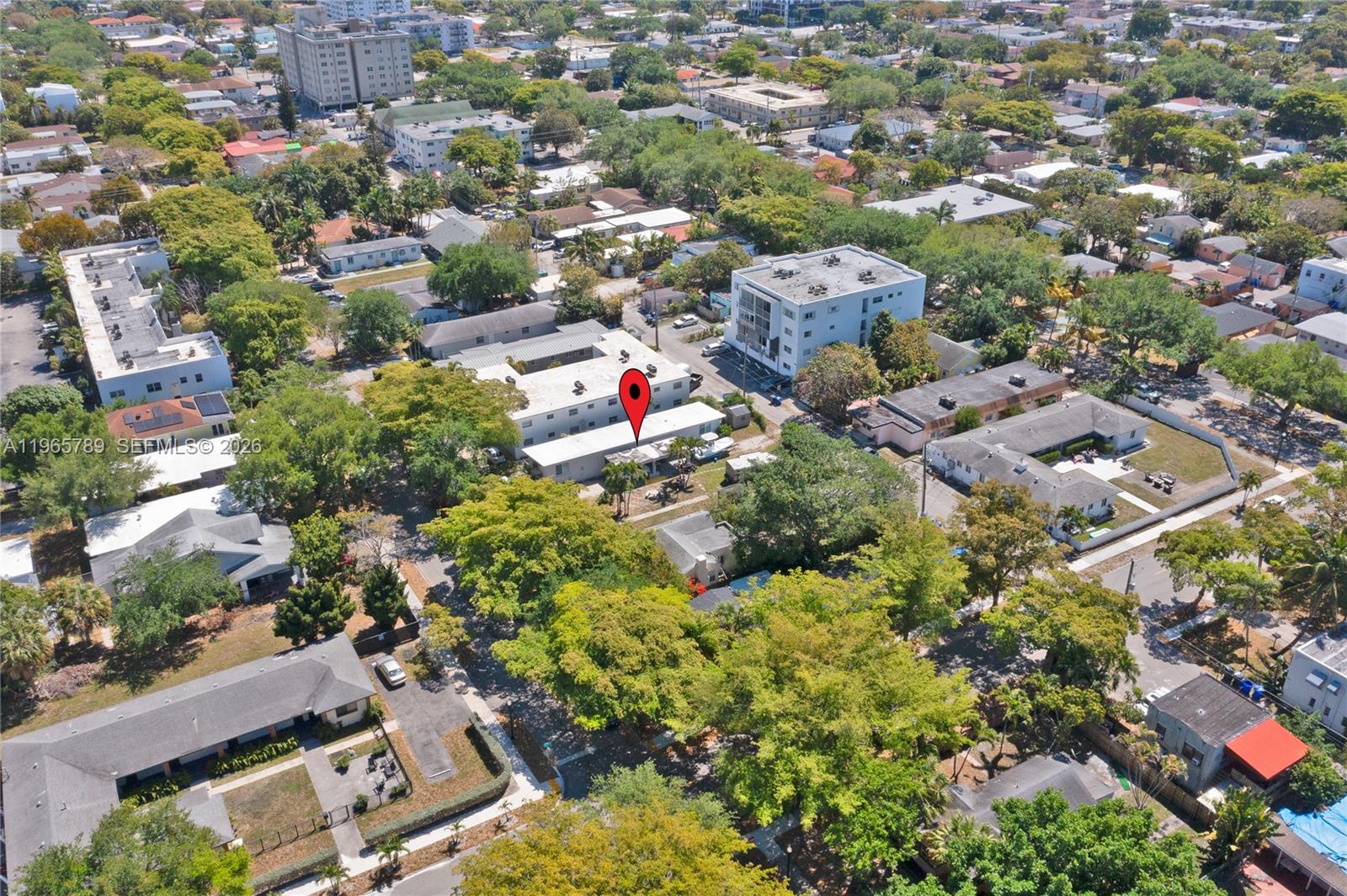 This aerial view shows a multi-story apartment building marked with a red location pin — 1946 Madison St, Hollywood FL 33020, HOLLYWOOD, FL