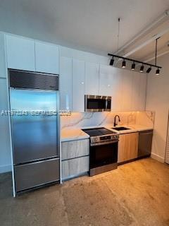 A modern kitchen features white cabinetry, stainless steel appliances, and light wood-toned lower cabinets — 700 NE 25th St # 1701, Miami FL 33137, MIAMI, FL