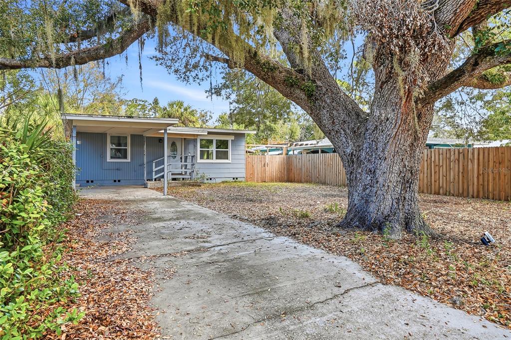 A blue house with a carport and a large oak tree in the front yard — 1137 40TH STREET, SARASOTA, FL