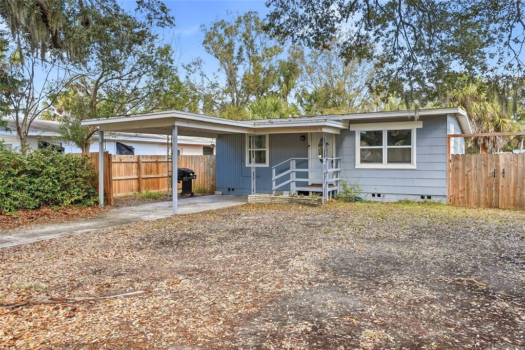A single-story blue house features a carport, a front porch with railings, and a yard — 1137 40TH STREET, SARASOTA, FL