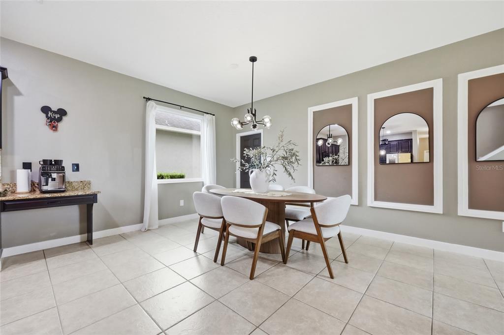 A dining room features a wooden table, white chairs, a chandelier, and wall-mounted mirrors — 3420 SCHOOLHOUSE ROAD, ST CLOUD, FL