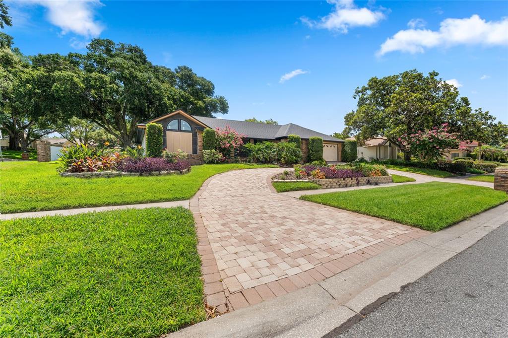 A single-story house with a paved driveway and landscaped front yard under a blue sky — 5415 BAY SIDE DRIVE, ORLANDO, FL