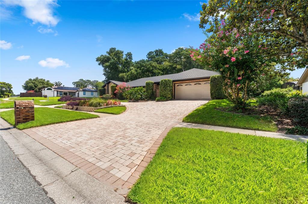 A single-story house with a paved driveway, brick mailbox, and landscaping under a blue sky — 5415 BAY SIDE DRIVE, ORLANDO, FL