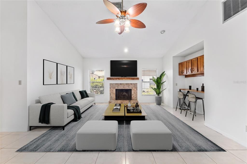 A living room features a stone fireplace, a wall-mounted television, and a built-in bar area — 5415 BAY SIDE DRIVE, ORLANDO, FL