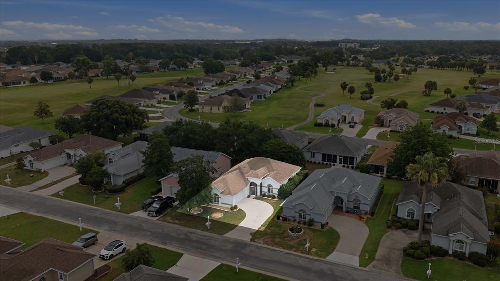 An aerial view shows a single-story house with a tan roof in a suburban neighborhood — 2379 NW 55TH AVENUE ROAD, OCALA, FL