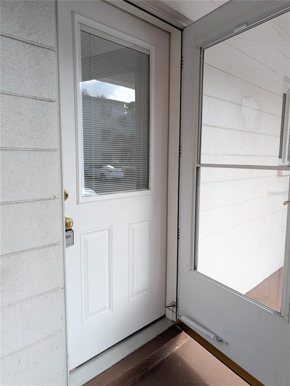 A white exterior door with a window and a screen door on a porch — 2303 SUNSET DRIVE UNIT H7, BRADENTON, FL