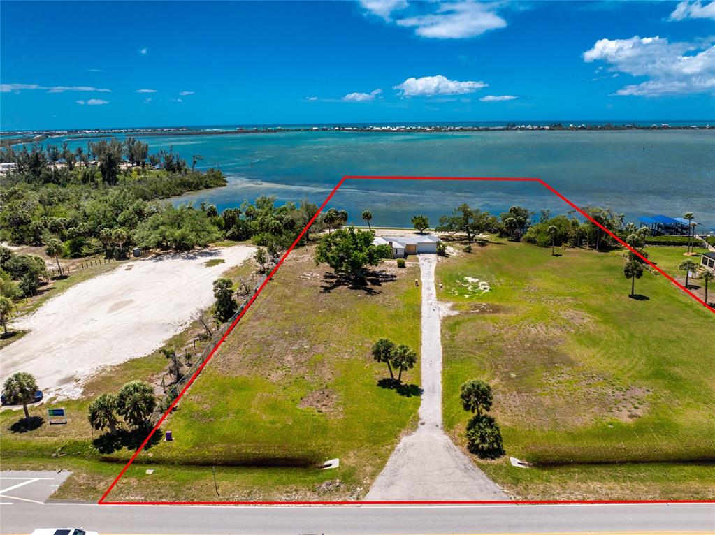 An aerial view shows a house on a large waterfront lot with a long driveway — 12500 PLACIDA ROAD, PLACIDA, FL