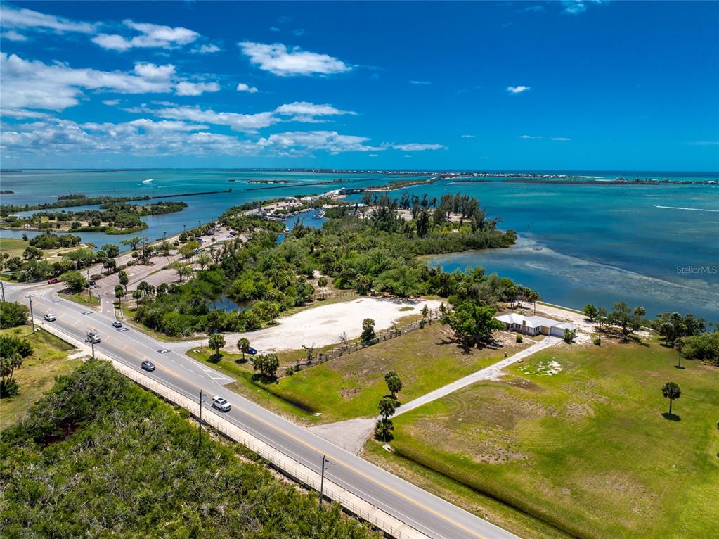 An aerial view shows a coastal road, a vacant lot, and a house near water — 12500 PLACIDA ROAD, PLACIDA, FL