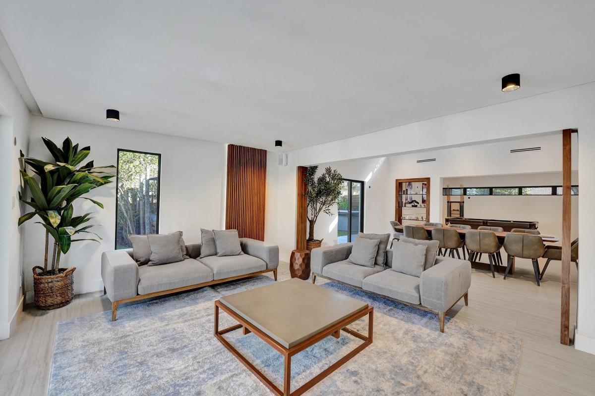 A living room with two gray sofas, a coffee table, and an adjacent dining area — 4417 SW 38th Terrace, Dania Beach FL 33312, DANIA BEACH, FL