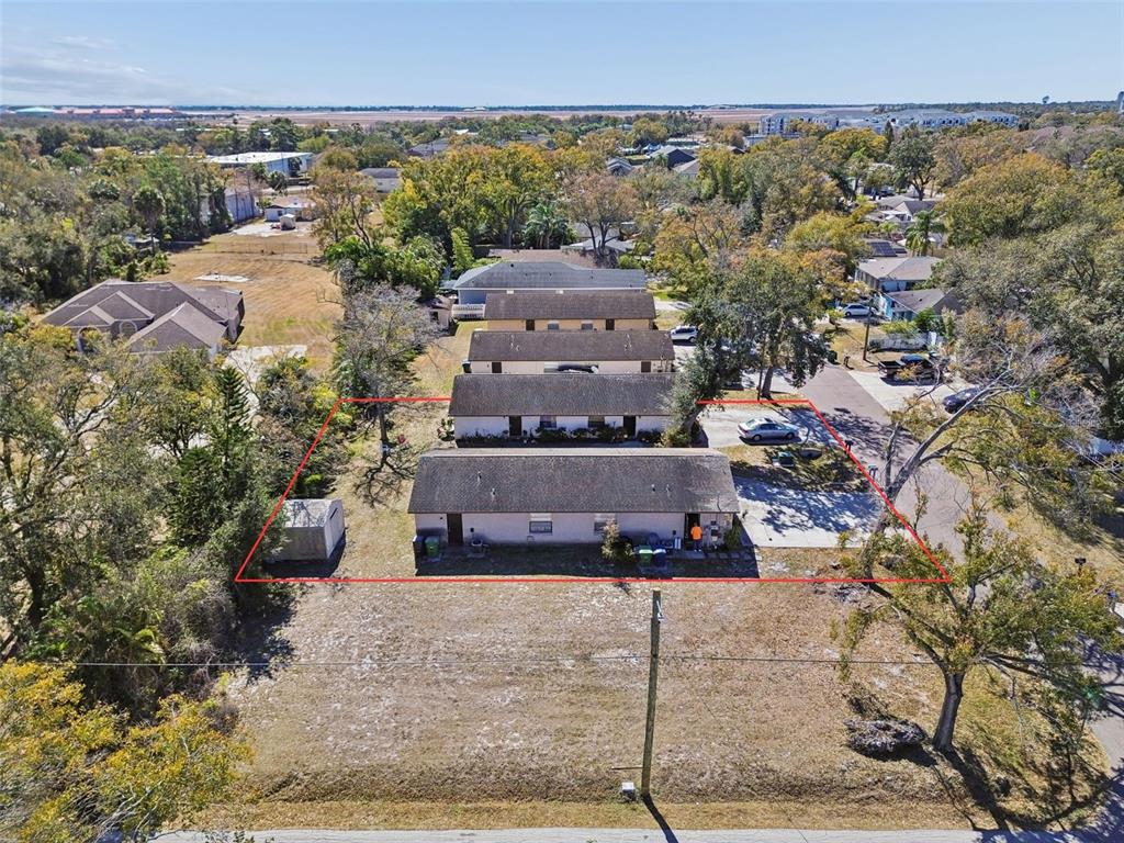An aerial view shows a single-story multi-unit residential building outlined in red on a lot — 6404 S ADELIA AVENUE, TAMPA, FL