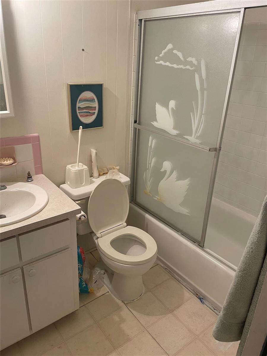 A bathroom features a vanity with a pink backsplash, a toilet, and a swan-etched shower door — 8581 SW 20th Place, Davie FL 33324, DAVIE, FL