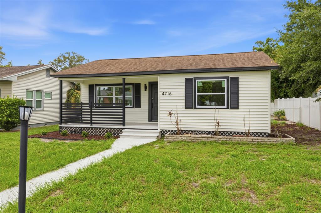 A single-story house with white siding, a front porch, and black shutters under a blue sky — 4716 17TH AVENUE N, ST PETERSBURG, FL