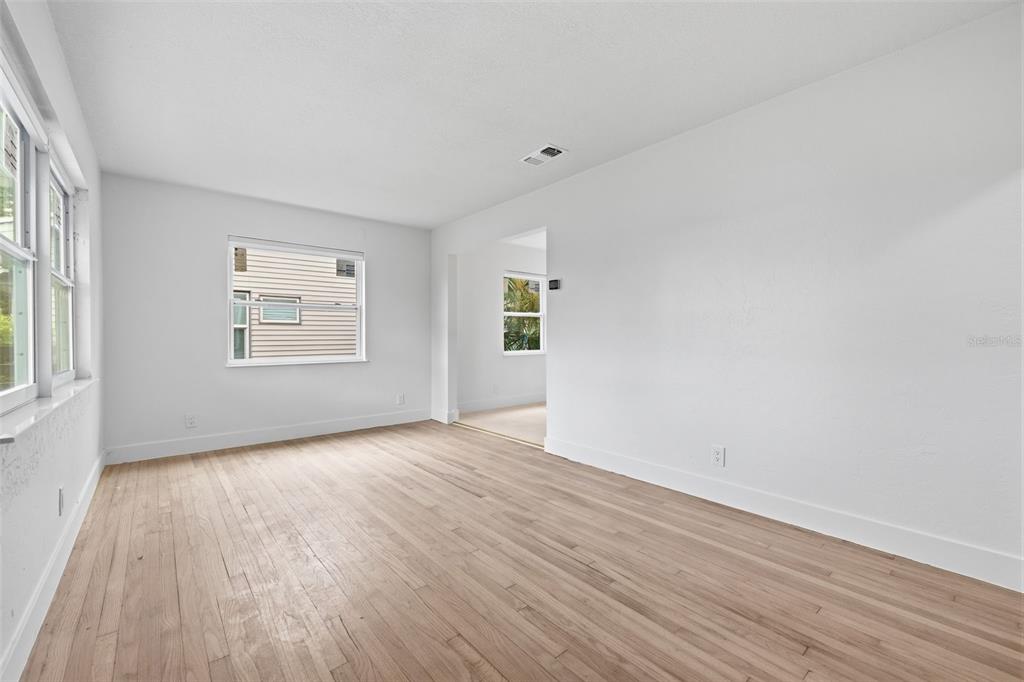 An empty room with white walls, light wood flooring, and two windows — 4716 17TH AVENUE N, ST PETERSBURG, FL