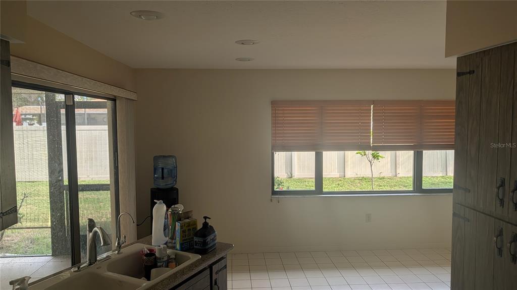 A kitchen with a double sink, sliding glass door, and a large window overlooking a yard — 3720 PIN OAKS STREET, SARASOTA, FL