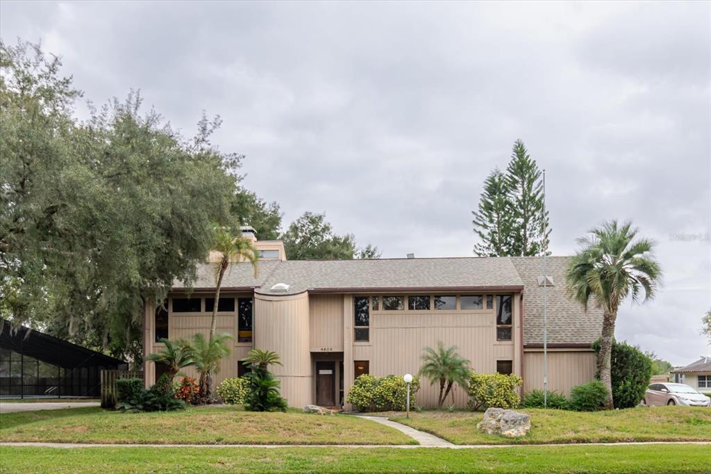 A two-story house with tan vertical siding, a shingled roof, and a front entryway — 4404 OLD ORCHARD DRIVE, TAMPA, FL