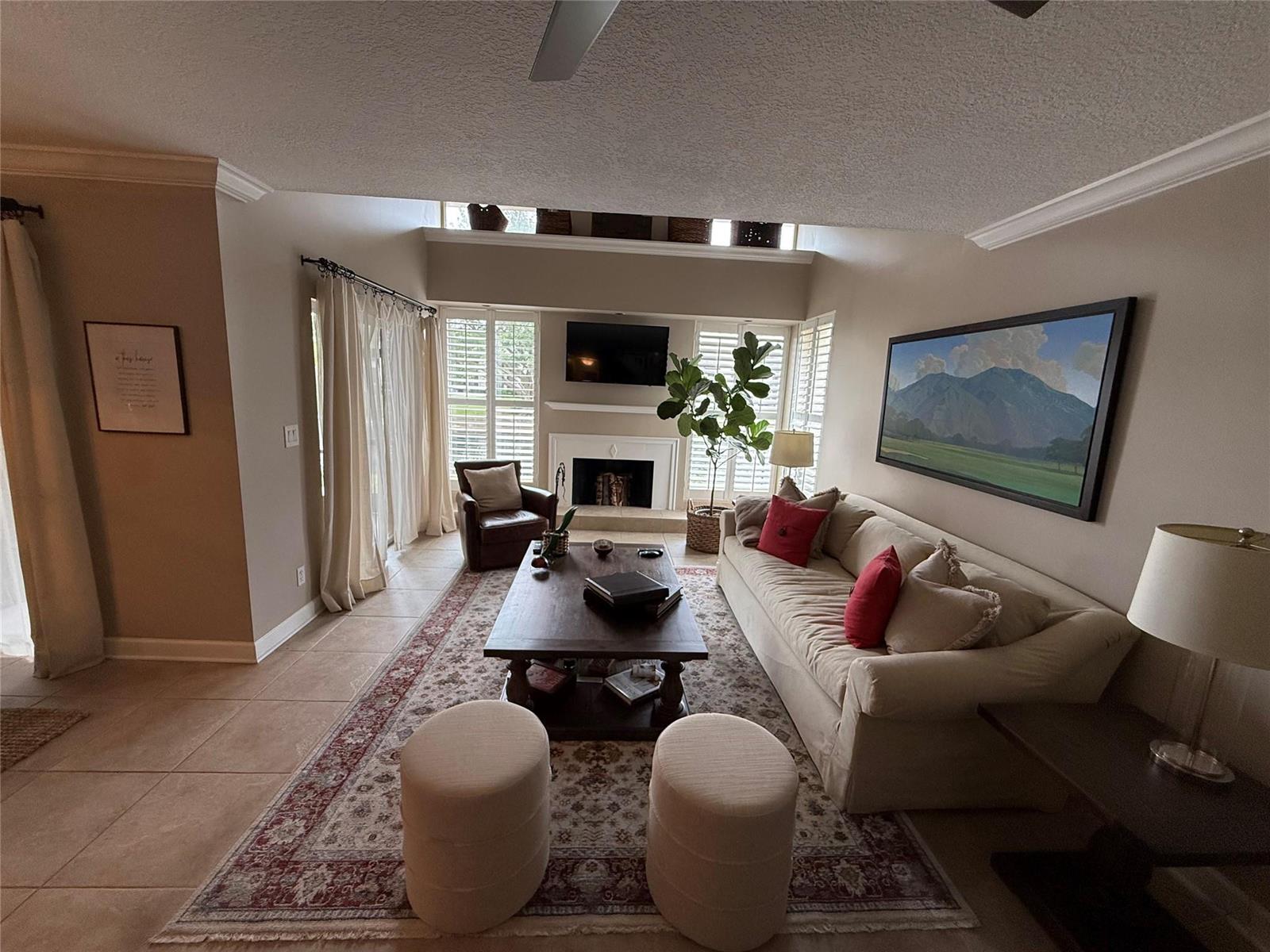 A living room features a fireplace, a large sofa, a coffee table, and tile flooring — 22861 Ironwedge Drive, Boca Raton FL 33433, BOCA RATON, FL