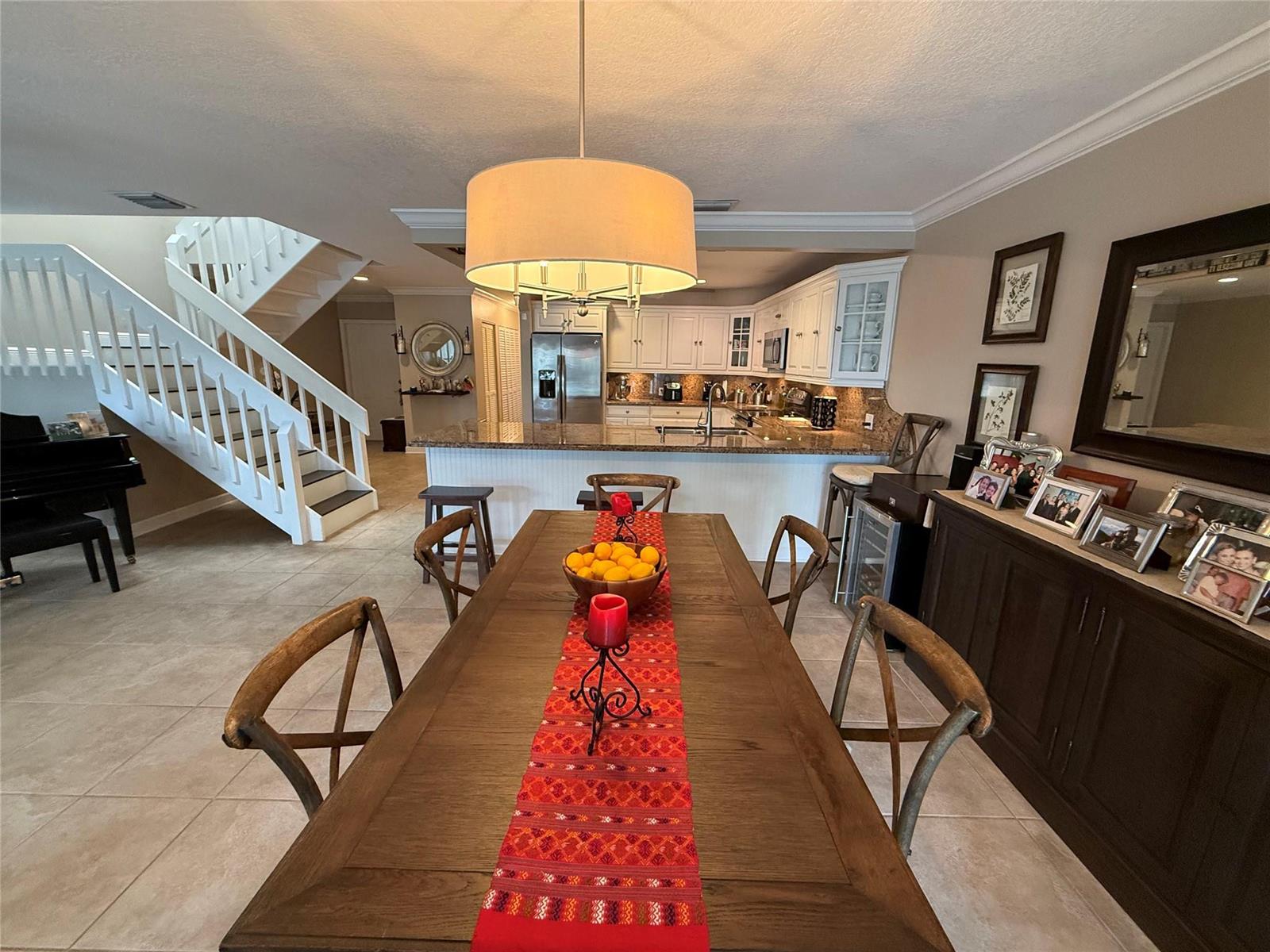 A dining area with a wooden table and chairs sits before an open-concept kitchen — 22861 Ironwedge Drive, Boca Raton FL 33433, BOCA RATON, FL