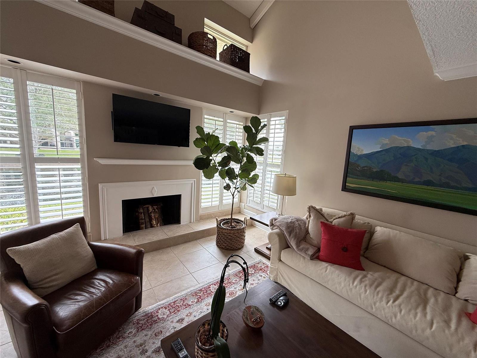 A living room features a fireplace, a mounted television, a sofa, and a leather chair — 22861 Ironwedge Drive, Boca Raton FL 33433, BOCA RATON, FL