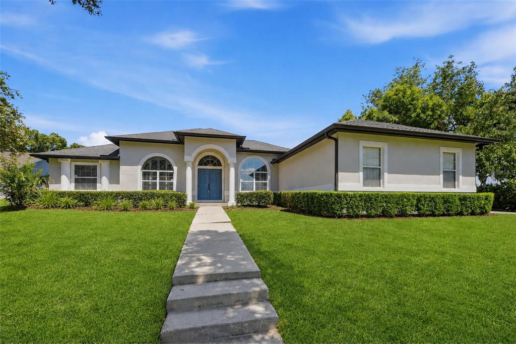 A single-story house with a blue front door, arched windows, and a concrete walkway — 5741 BAY SIDE DRIVE, ORLANDO, FL