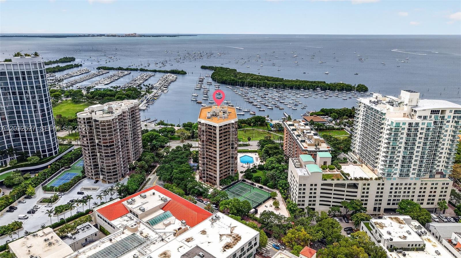 An aerial view shows several high-rise residential buildings near a marina and the ocean — 2901 S Bayshore Dr # 4A, Miami FL 33133, MIAMI, FL