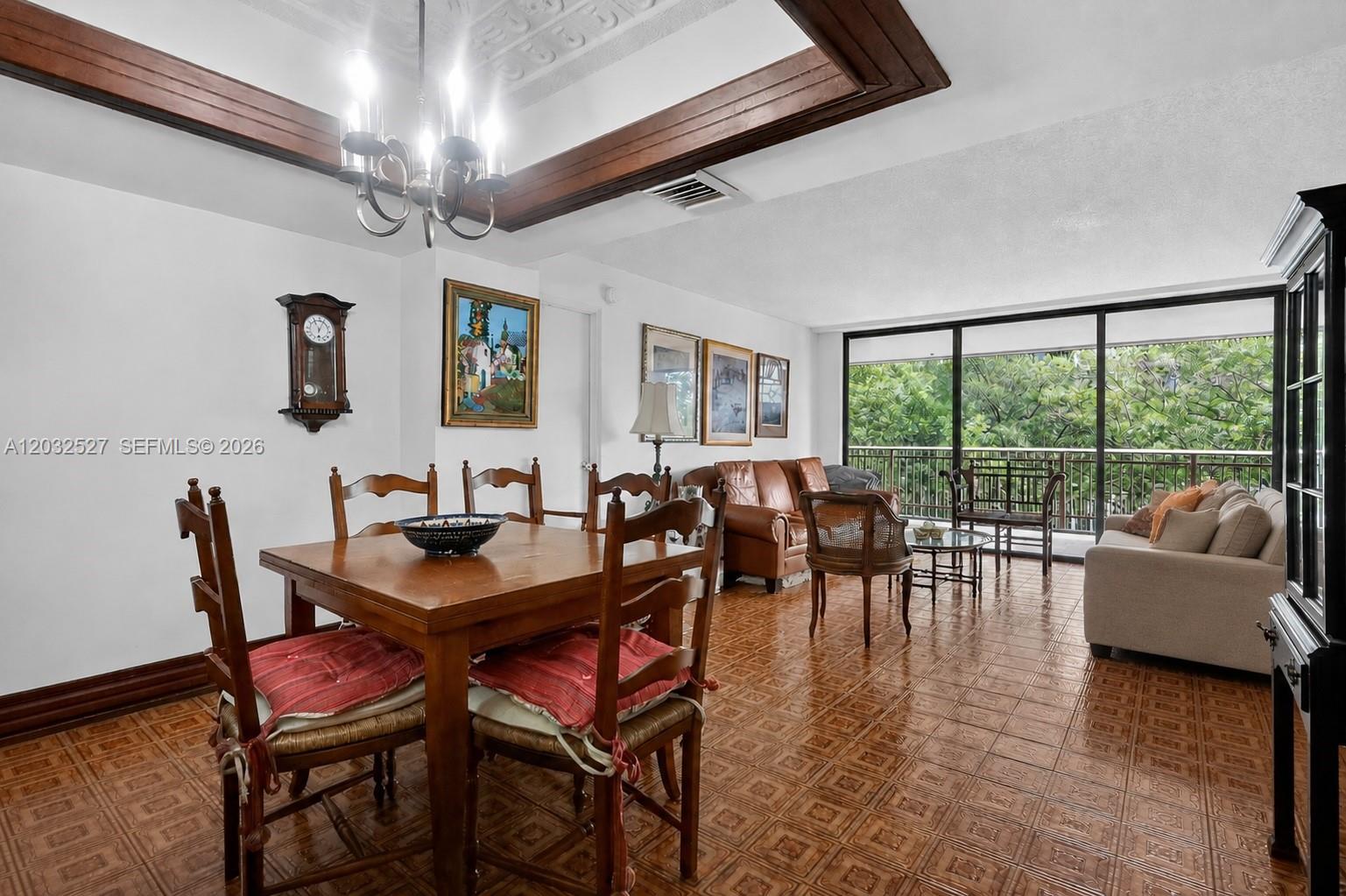 A dining and living area features wood-paneled ceiling beams, tile flooring, and a balcony view — 2901 S Bayshore Dr # 4A, Miami FL 33133, MIAMI, FL