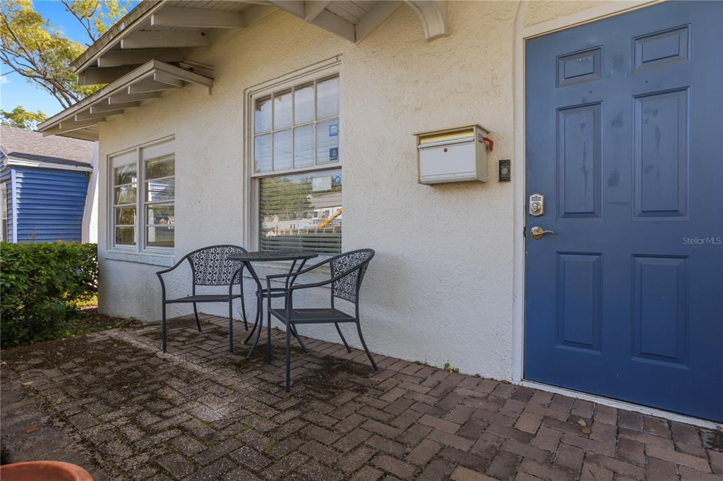 A brick patio sits in front of a house with a blue door and window — 827 IRMA AVENUE, ORLANDO, FL