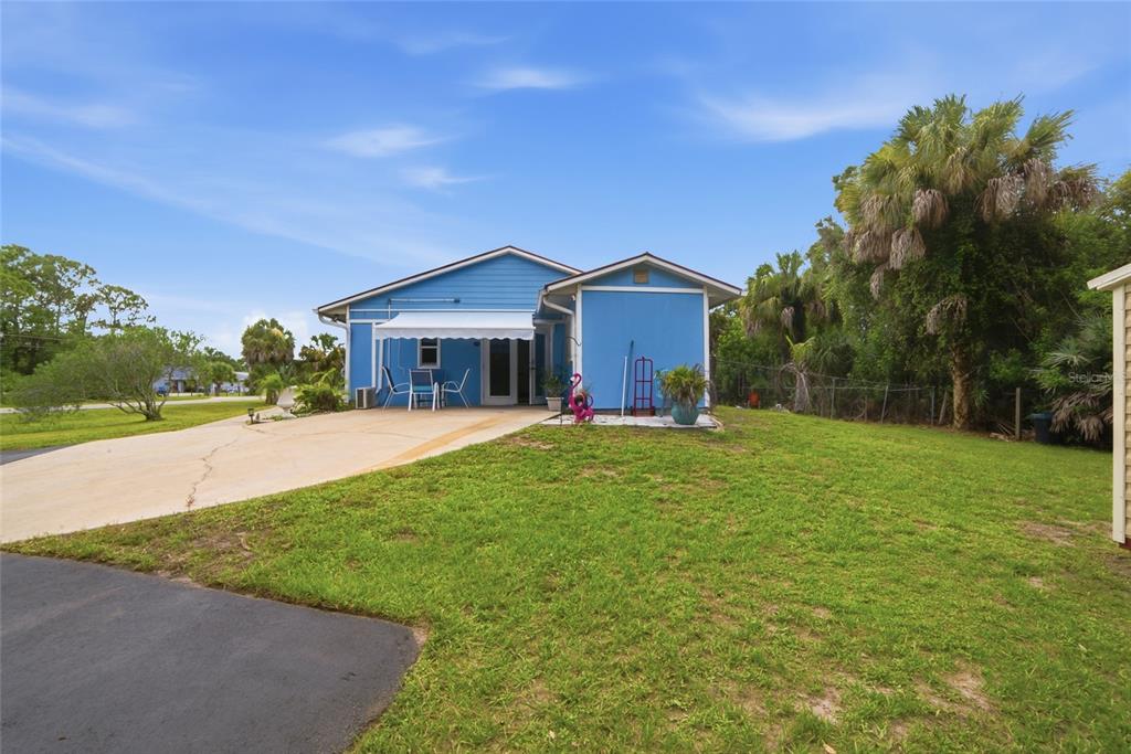 A blue single-story house with a concrete driveway and a white retractable awning — 2300 HALL ROAD, MALABAR, FL