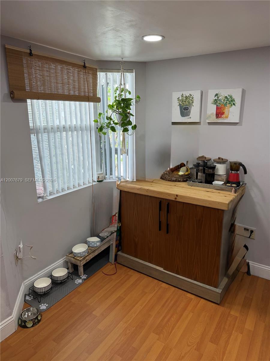 A corner room features a wooden cabinet, pet feeding stations, and a window with blinds — PEMBROKE PINES, FL