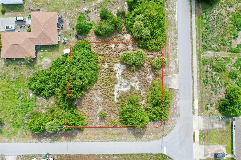 An aerial view shows a vacant, rectangular lot outlined in red between two residential streets — 27147 SUNNYBROOK ROAD, PUNTA GORDA, FL