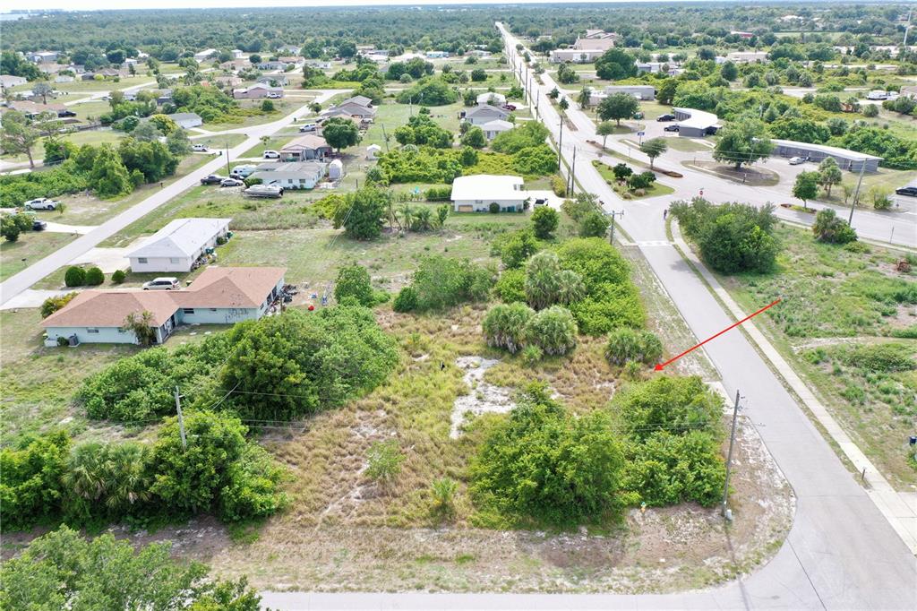 An aerial view shows a vacant, brush-covered residential lot situated at a street corner — 27147 SUNNYBROOK ROAD, PUNTA GORDA, FL