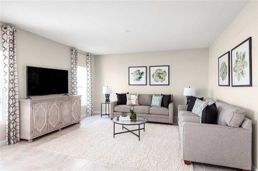 A living room features two gray sofas, a glass coffee table, and a television console — 11464 SE 77TH AVENUE, BELLEVIEW, FL