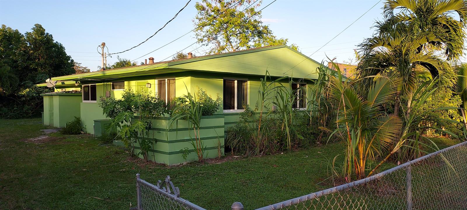 A lime green single-story house with a low-pitched roof sits on a grassy lot — 171 NE 117th Street, Miami FL 33161, MIAMI, FL