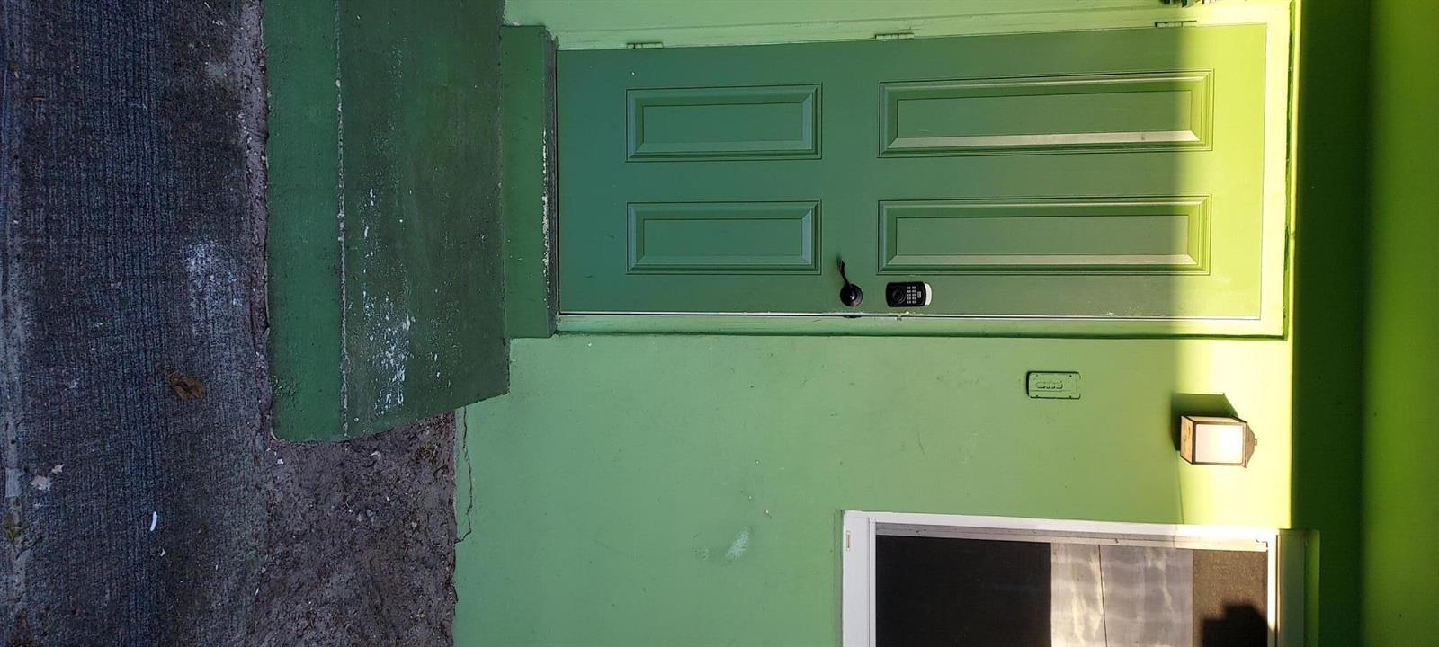 A green exterior wall features a matching green door with a keypad lock — 171 NE 117th Street, Miami FL 33161, MIAMI, FL