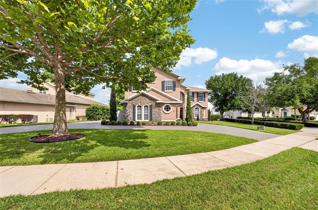 A two-story house with a stone facade and a large tree in the front yard — 279 ZACHARY WADE STREET, WINTER GARDEN, FL