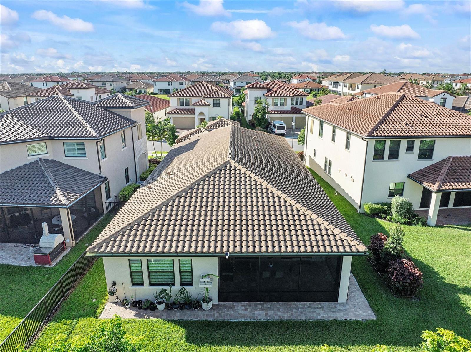 An aerial view of a suburban house with a tiled roof and a screened-in patio — 12245 N Baypoint Circle, Parkland FL 33076, PARKLAND, FL