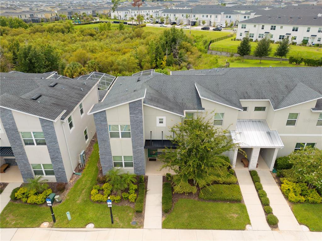 An aerial view of a two-story townhouse with stone accents and a landscaped front yard — 302 OCEAN COURSE AVENUE, DAVENPORT, FL