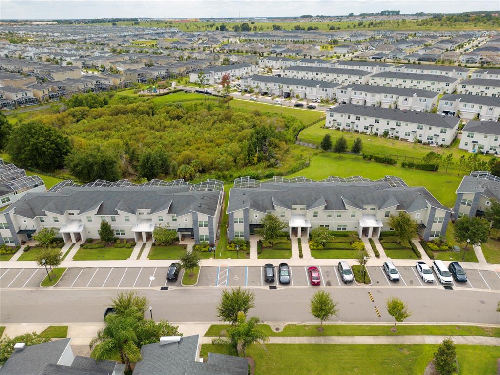 An aerial view shows two multi-unit townhomes with parking spaces in a suburban neighborhood — 302 OCEAN COURSE AVENUE, DAVENPORT, FL