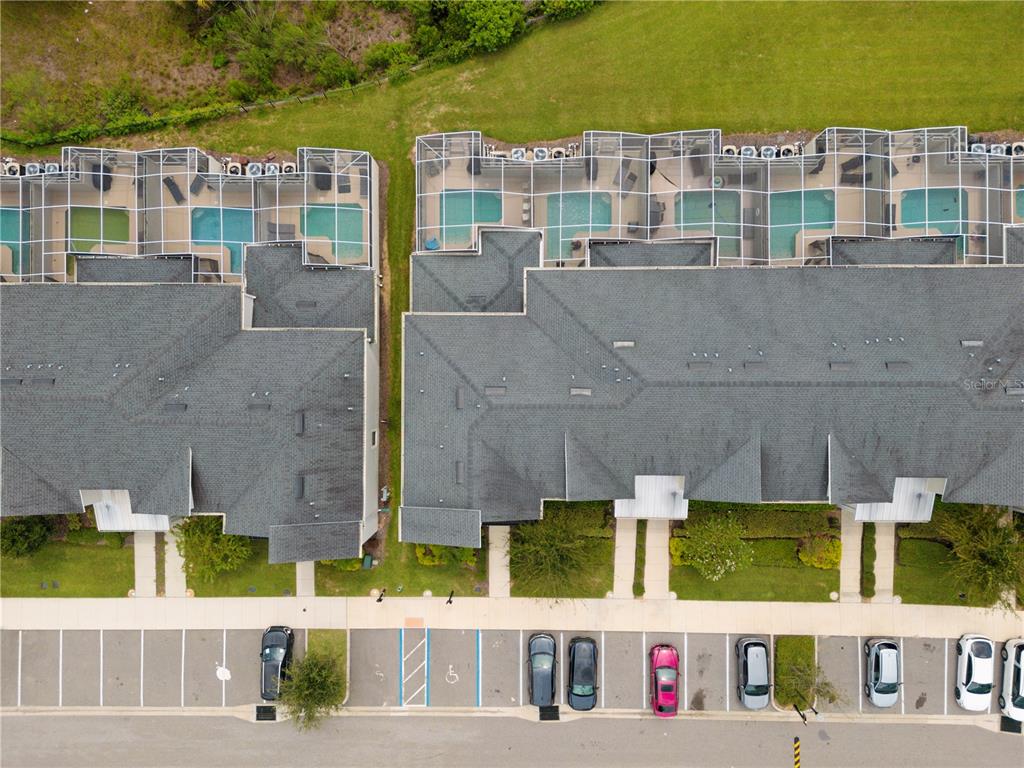An aerial view shows two townhome buildings with screened-in pools and a parking lot — 302 OCEAN COURSE AVENUE, DAVENPORT, FL