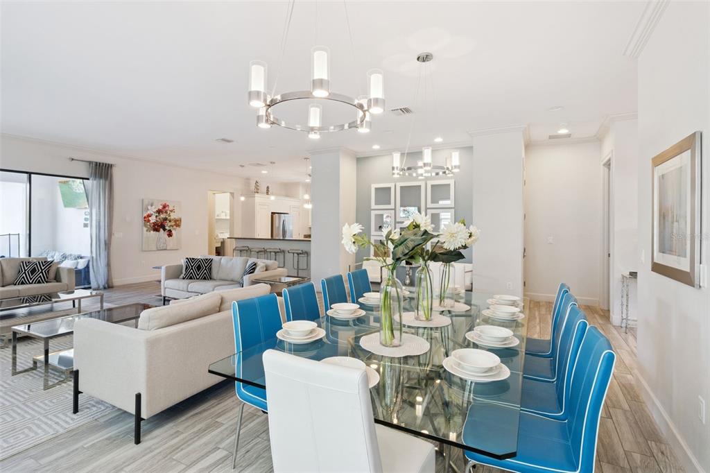 A dining room with a glass table and blue chairs sits adjacent to a living area — 7423 SPARKLING COURT, REUNION, FL