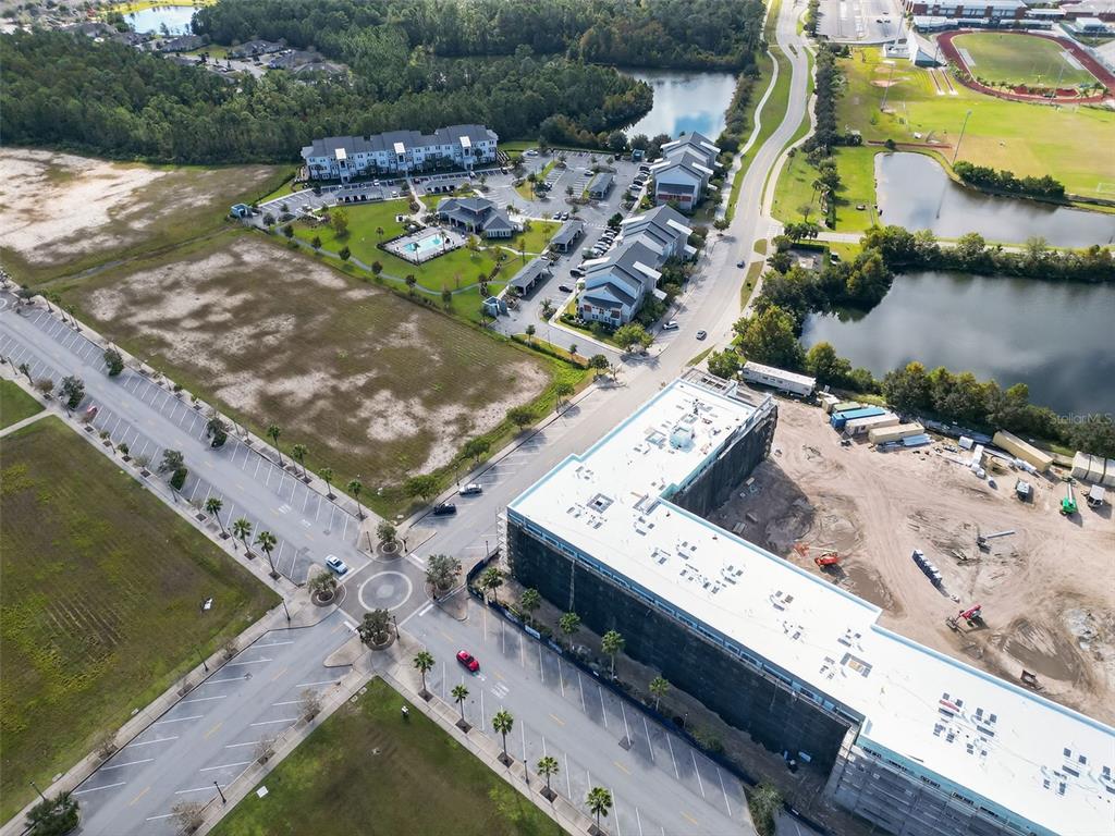 An aerial view shows a construction site, apartment buildings, parking lots, and nearby ponds — 469 BULLDOG DRIVE UNIT 2, PALM COAST, FL