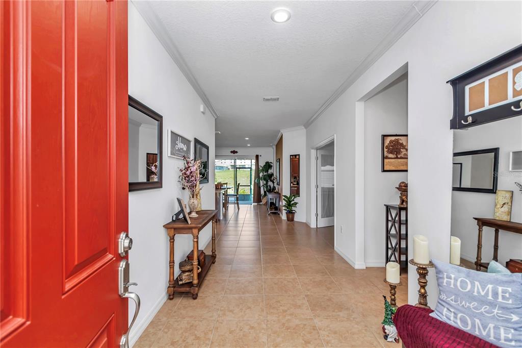 A bright entryway with tile flooring leads to an open living area and rear patio — 10019 SW 96TH STREET, OCALA, FL